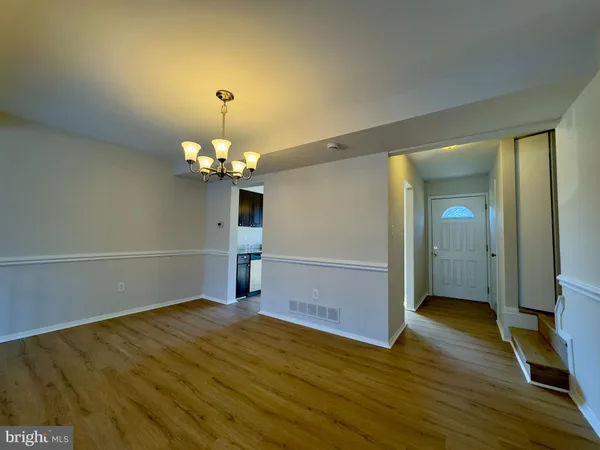 a view of a room with wooden floor chandelier and closet