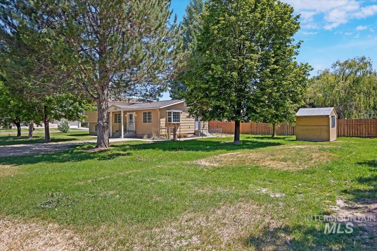 1940 Q Street Heyburn, ID 83336 - Photo 24 of 30 Spacious grassy yard featuring mature trees and a wooden privacy fence