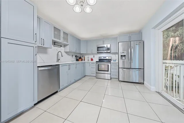 a kitchen with white cabinets stainless steel appliances and a window