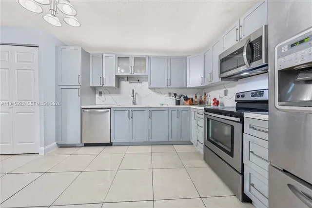 a kitchen with stainless steel appliances granite countertop a sink and a stove