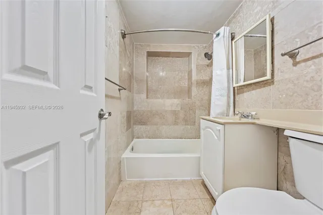 a bathroom with a granite countertop bathtub shower and toilet