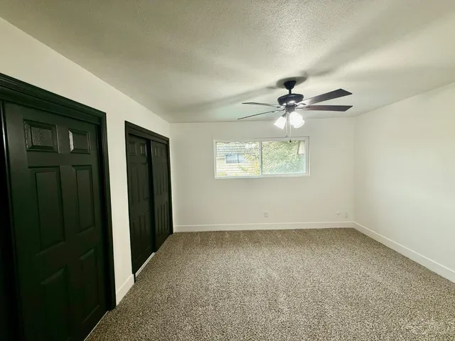 an empty room with fan and windows