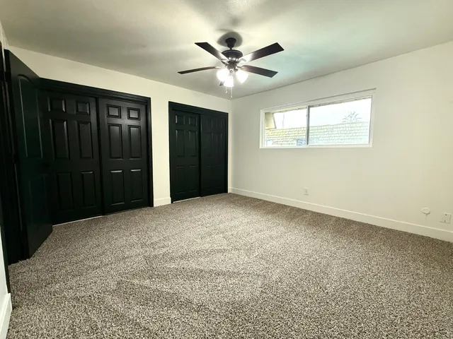 a view of an empty room with a ceiling fan
