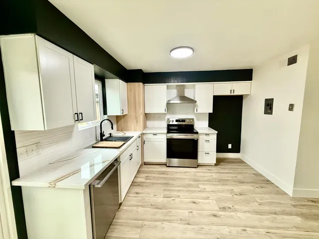 a large kitchen with a stove and a sink