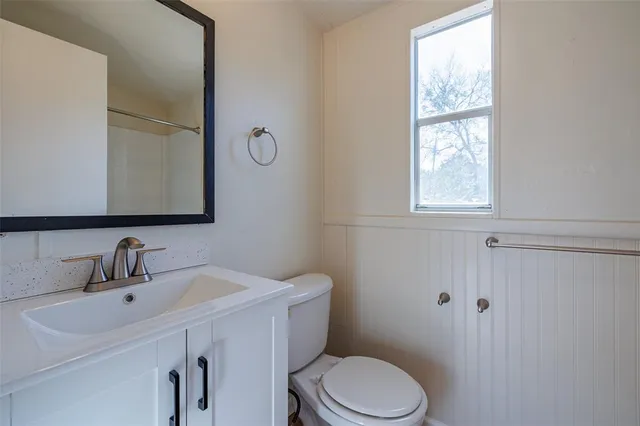 a bathroom with a sink a toilet and a mirror