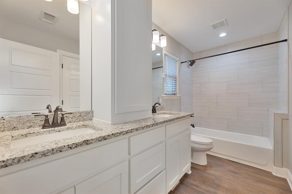 1713 Bronco Road Granbury, TX 76049 - Photo 18 of 23 Bathroom featuring a dual vanity with granite countertops, integrated sinks, and bronze-finish fixtures