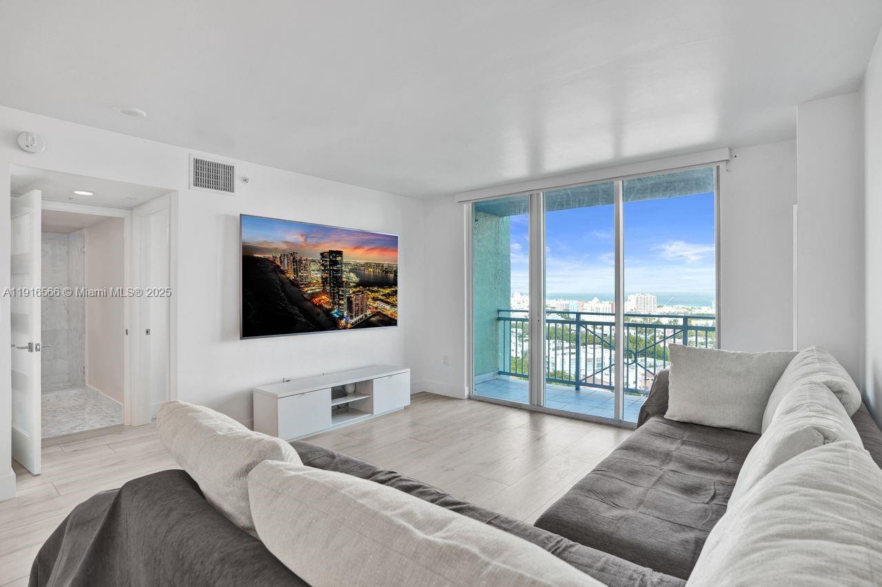 90 Alton Road, Unit 1907 Miami Beach, FL 33139 - Photo 1 of 45 a living room with furniture and a flat screen tv