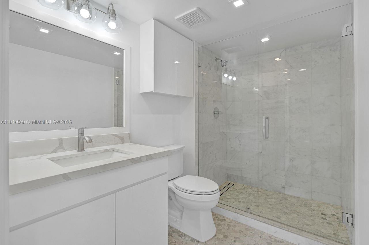 90 Alton Road, Unit 1907 Miami Beach, FL 33139 - Photo 17 of 45 a bathroom with a sink a toilet and shower