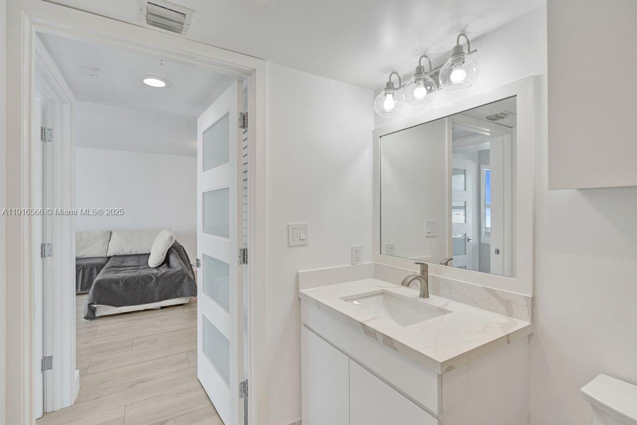 90 Alton Road, Unit 1907 Miami Beach, FL 33139 - Photo 18 of 45 a en suite bathroom with a sink double vanity and a mirror