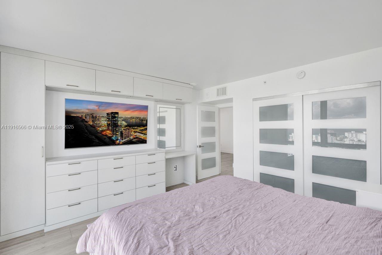 90 Alton Road, Unit 1907 Miami Beach, FL 33139 - Photo 23 of 45 a bedroom with a bed and television