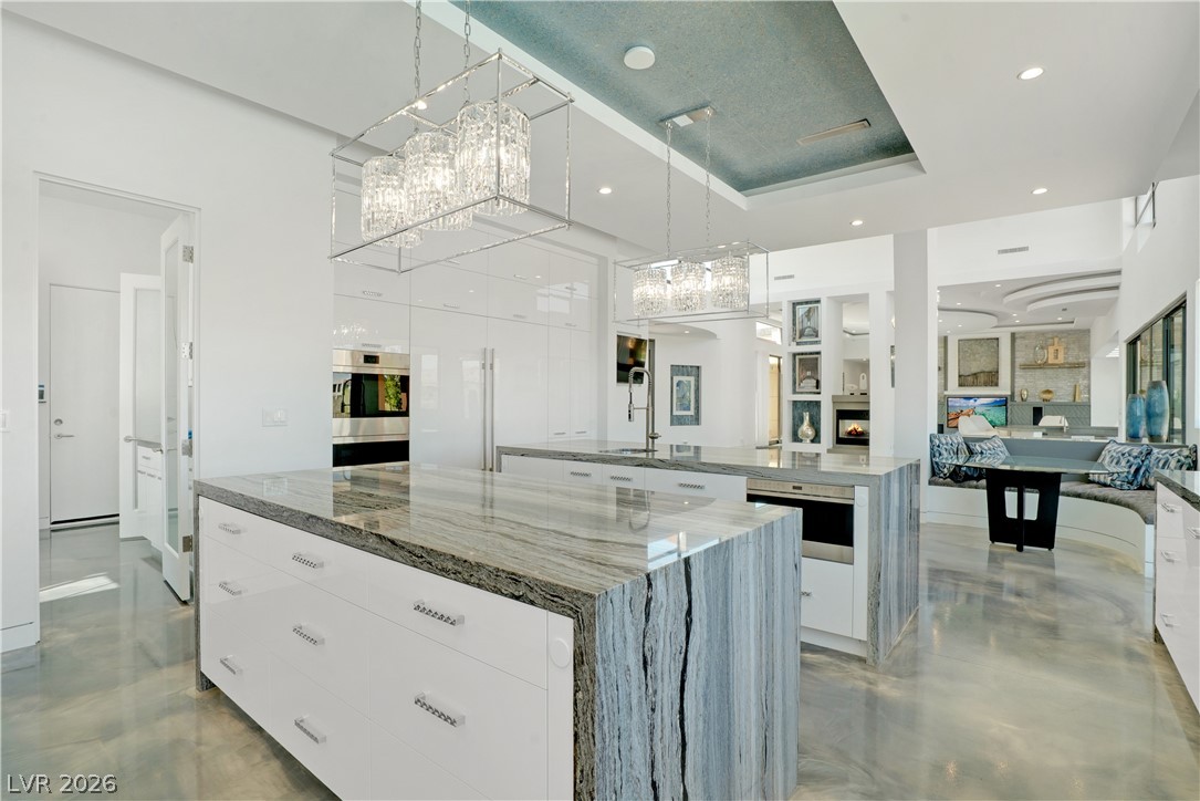 10 Ridge Blossom Road Las Vegas, NV 89135 - Photo 12 of 64 Kitchen with white cabinets, light stone countertops, hanging light fixtures, modern cabinets, and a chandelier