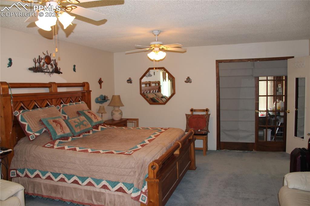 33375 Fogarty Road Calhan, CO 80808 - Photo 11 of 50 a bed room with a bed mirror and a chandelier