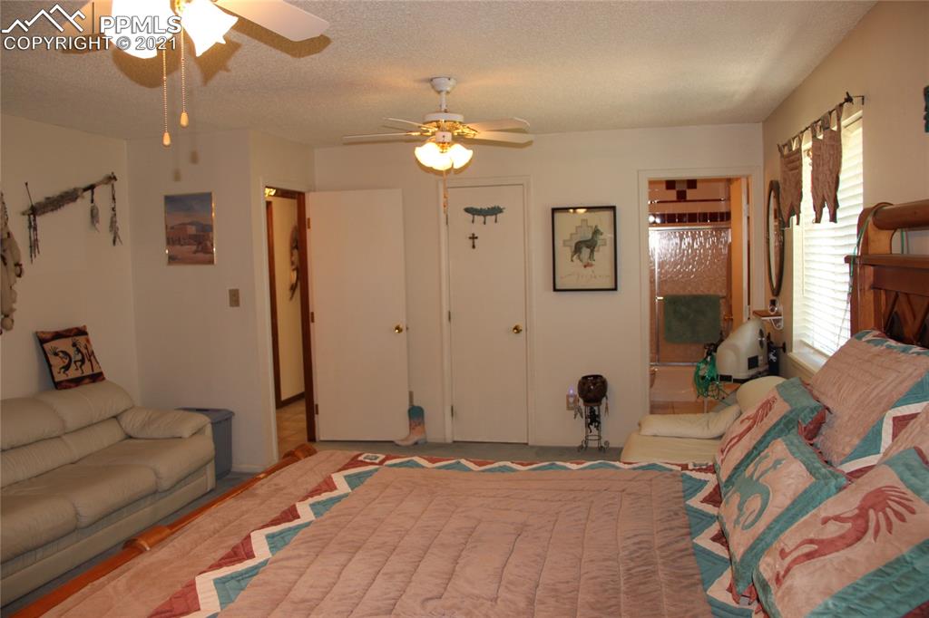 33375 Fogarty Road Calhan, CO 80808 - Photo 12 of 50 a bedroom with a bed and a chandelier