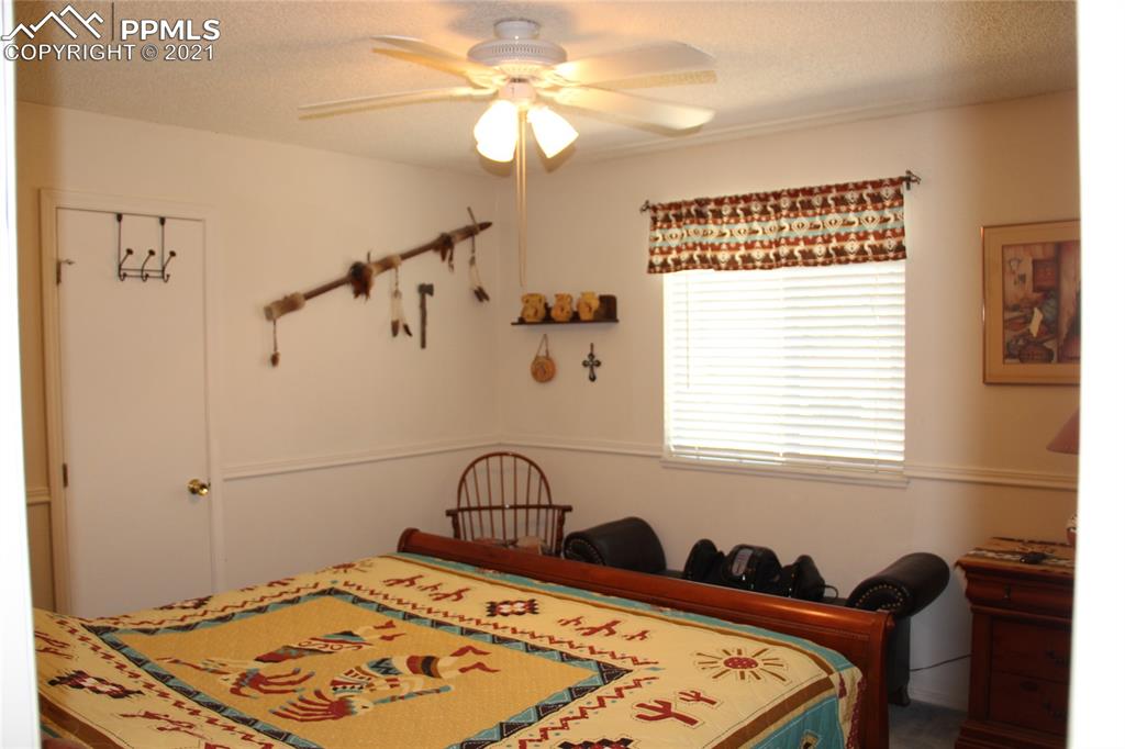 33375 Fogarty Road Calhan, CO 80808 - Photo 15 of 50 a bedroom with a bed and a chandelier