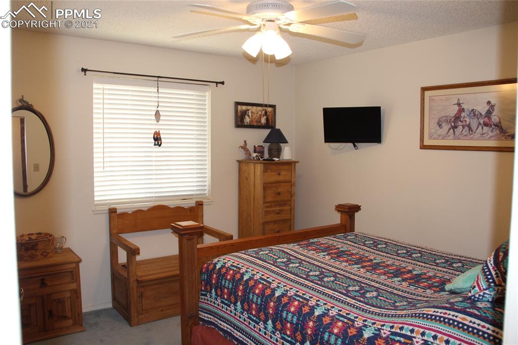 33375 Fogarty Road Calhan, CO 80808 - Photo 16 of 50 a bedroom with a bed and a chandelier