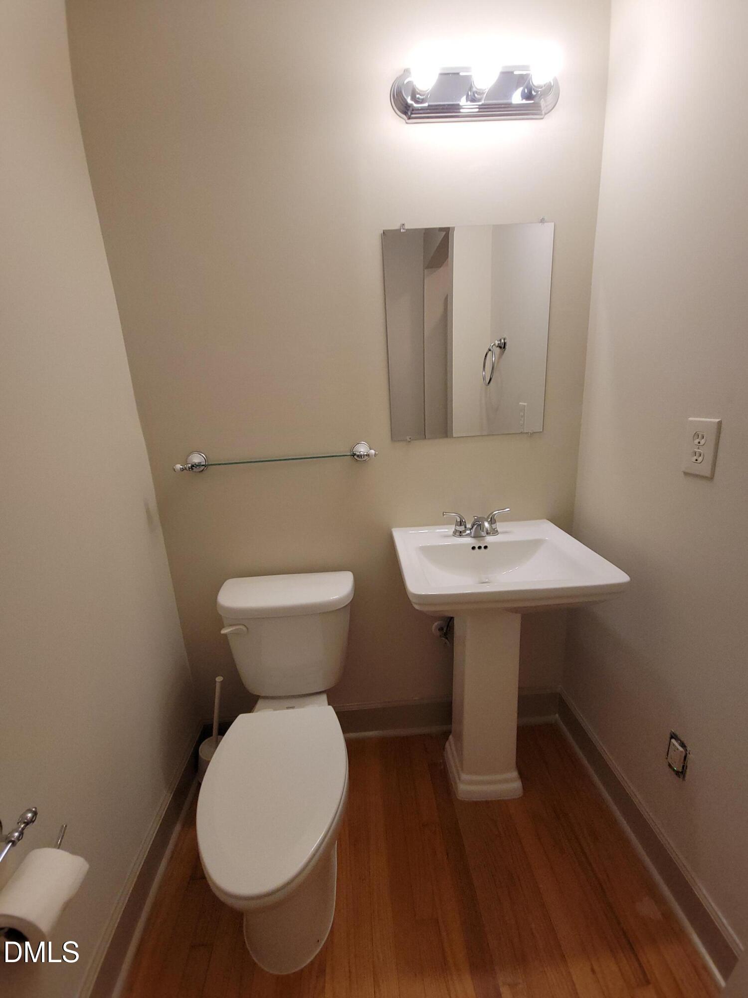 7000 Holly Springs Road Raleigh, NC 27606 - Photo 16 of 24 a bathroom with a toilet a sink and a mirror