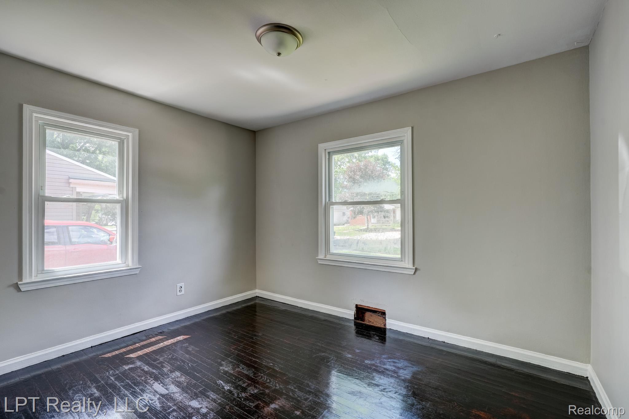 23038 Violet Street Farmington, MI 48336 - Photo 12 of 29 Room featuring dark wood-finish flooring, light gray walls, and white trim