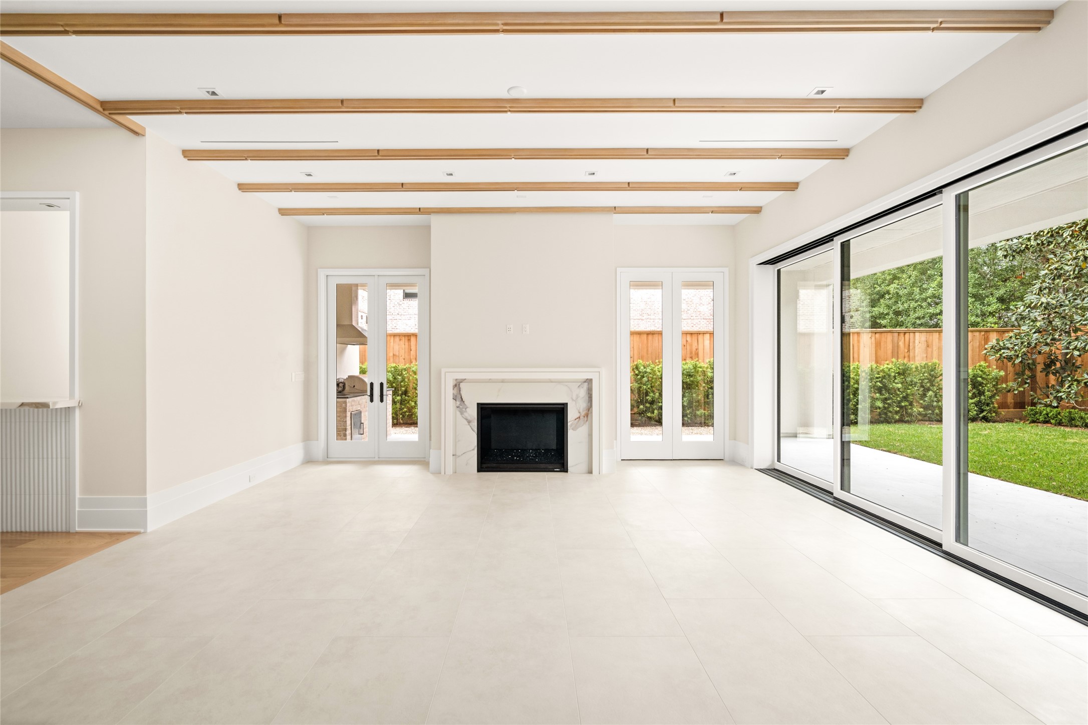 4006 Overbrook Lane Houston, TX 77027 - Photo 11 of 50 A statement fireplace anchors the space, while modern white oak beam detailing and expansive glass doors create a seamless connection to the outdoors.