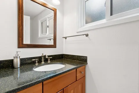 a spacious bathroom with a granite countertop tub sink a mirror a shower and vanity