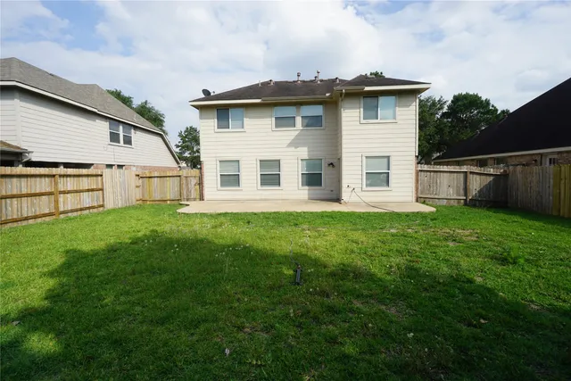 a white house that has tree in front of it