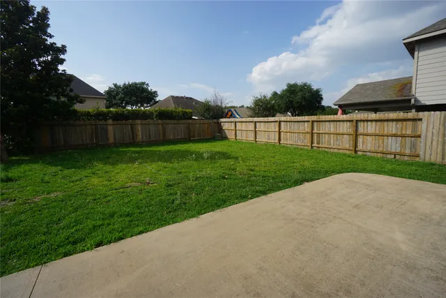 a view of a backyard with potted plants and wooden fence