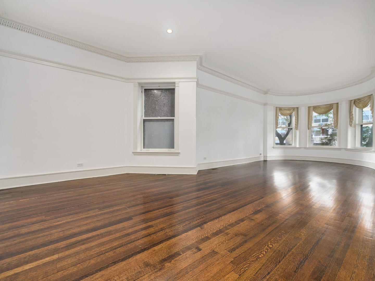 3020 North Sheridan Road, Unit 1N Chicago, IL 60657 - Photo 7 of 29 a view of an empty room with wooden floor and a window