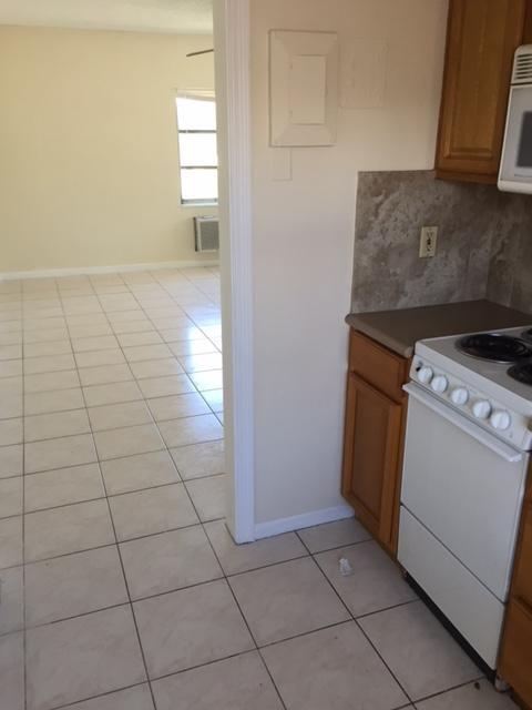101 South Golfview Road, Unit 16 Lake Worth Beach, FL 33460 - Photo 15 of 16 a kitchen with a stove top oven and cabinets
