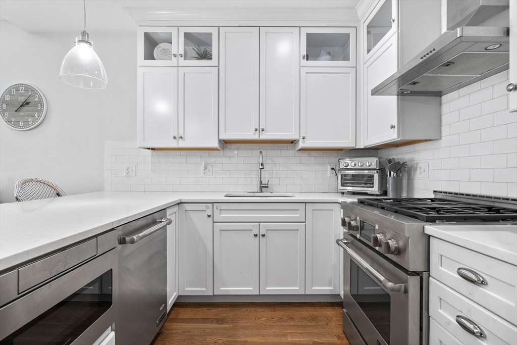 25 Mercer Street, Unit PH5 Boston, MA 02127 - Photo 11 of 22 a kitchen with granite countertop white cabinets and white appliances