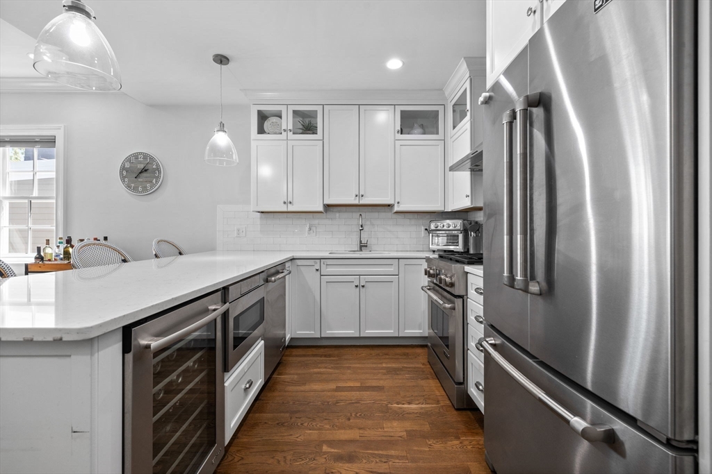25 Mercer Street, Unit PH5 Boston, MA 02127 - Photo 3 of 22 a kitchen with stainless steel appliances sink a stove and a refrigerator