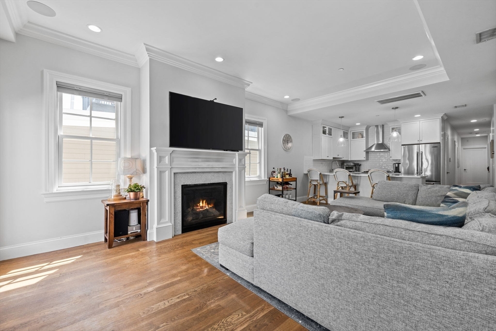 25 Mercer Street, Unit PH5 Boston, MA 02127 - Photo 5 of 22 a living room with furniture a fireplace and a flat screen tv