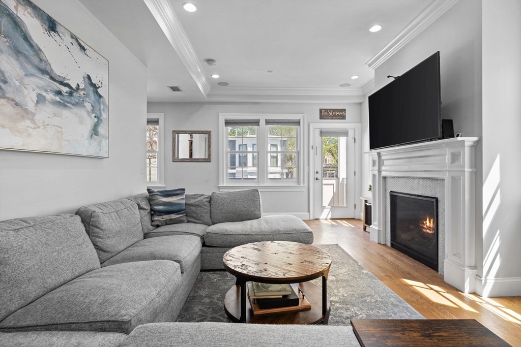 25 Mercer Street, Unit PH5 Boston, MA 02127 - Photo 10 of 22 a living room with furniture a flat screen tv and a fireplace
