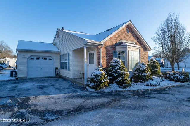 a view of a house with a yard and large tree