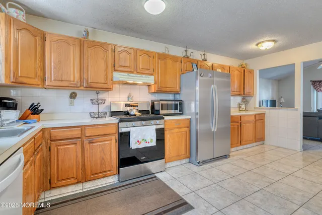 a kitchen with a refrigerator sink and cabinets