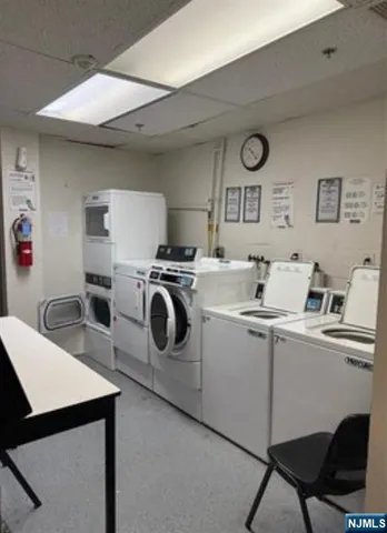 a utility room with dryer washer and a view of living room