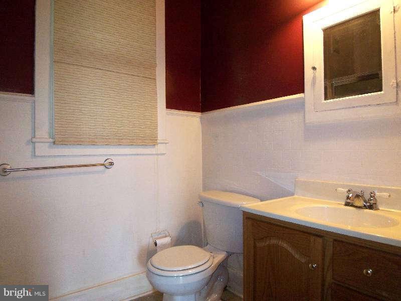 2 Warren Street Berkeley Springs, WV 25411 - Photo 9 of 30 a bathroom with a toilet a sink and mirror