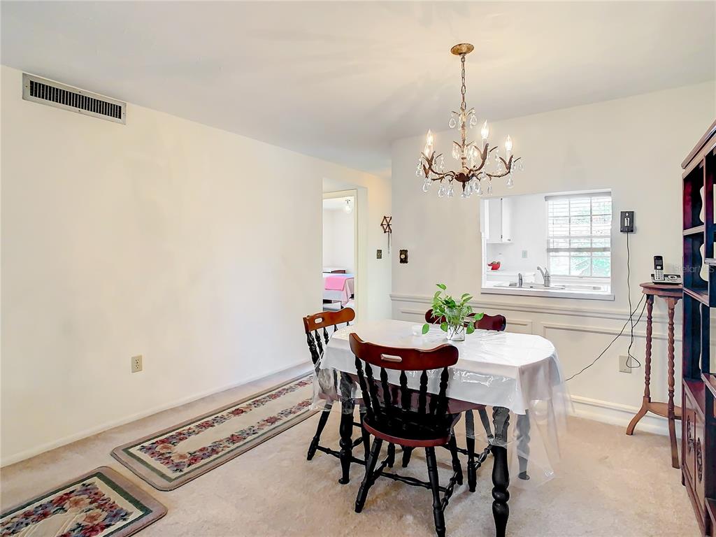 4230 Redcliff Place, Unit 4230 New Port Richey, FL 34652 - Photo 7 of 42 a view of a dining room with furniture and a chandelier