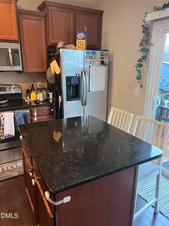 a kitchen with stainless steel appliances granite countertop a sink a stove and a microwave