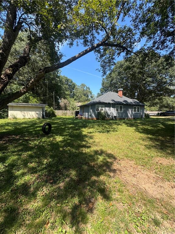 1230 South Madison Avenue Monroe, GA 30655 - Photo 3 of 37 a view of a swimming pool with lawn chairs and large trees