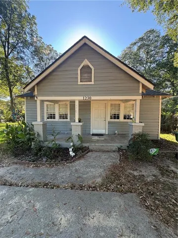 a front view of a house with a yard and trees