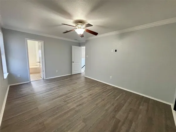 an empty room with wooden floor chandelier fan and closet area