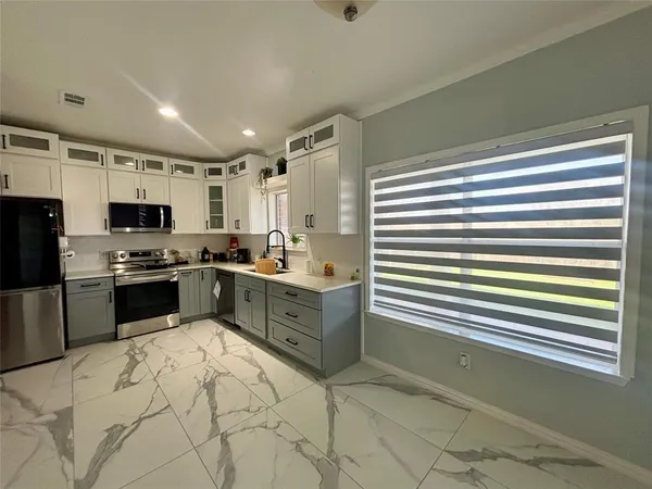a kitchen with granite countertop stainless steel appliances a sink and cabinets