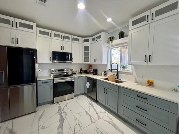 a kitchen with stainless steel appliances granite countertop a refrigerator sink and microwave