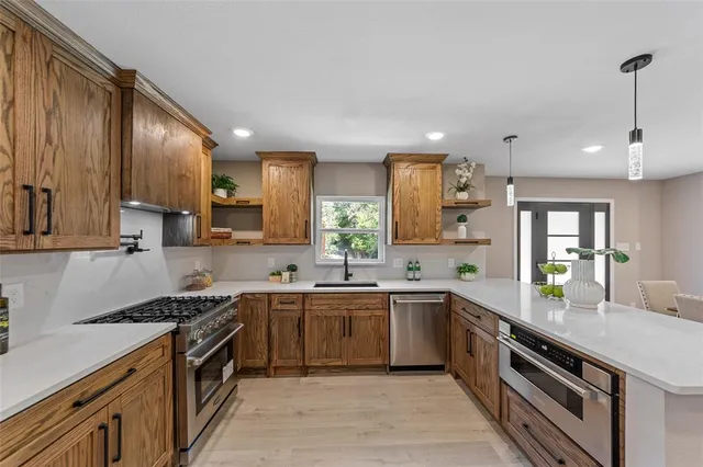 a kitchen with stainless steel appliances a sink stove and cabinets