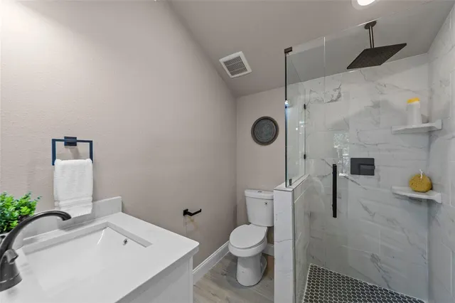 a bathroom with a sink a toilet and shower