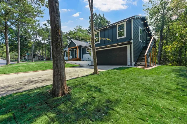 a view of a house with backyard and a tree