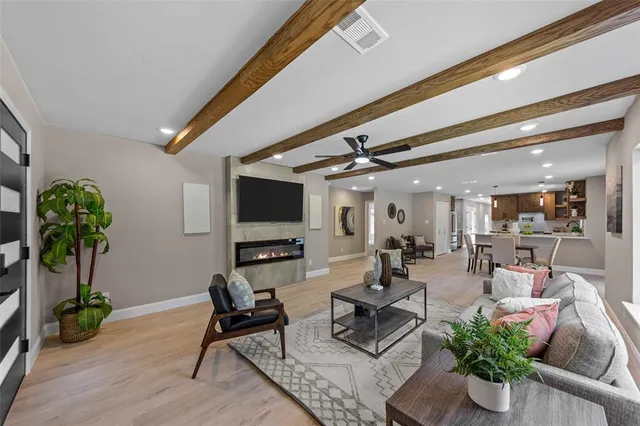 a living room with furniture floor to ceiling window and a potted plant