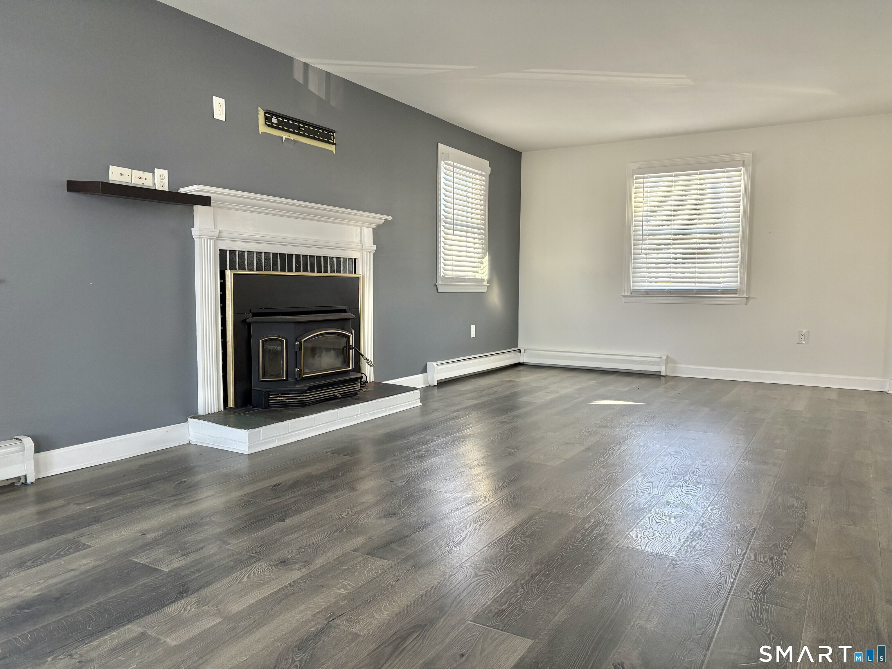 31 Pegasus Drive Groton, CT 06340 - Photo 11 of 17 an empty room with wooden floor fireplace and windows