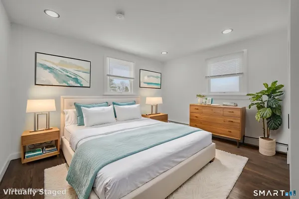 a bedroom with a bed and a potted plant