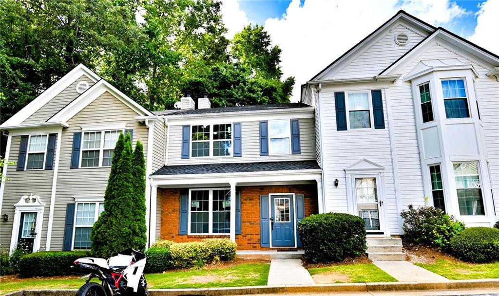 a front view of a house with yard and green space
