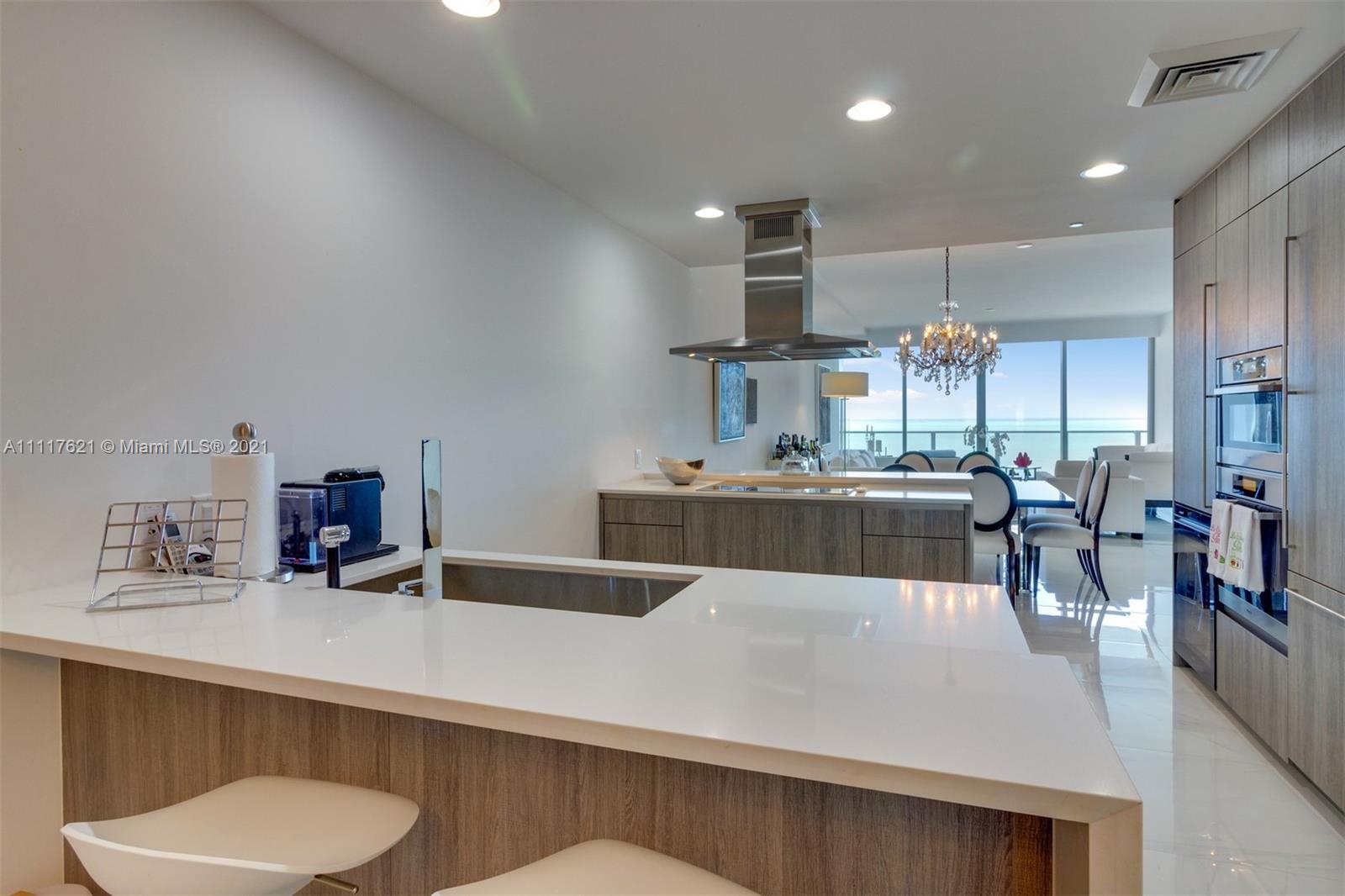 360 Ocean Drive, Unit 1106S Key Biscayne, FL 33149 - Photo 12 of 35 a large kitchen with a table and chairs